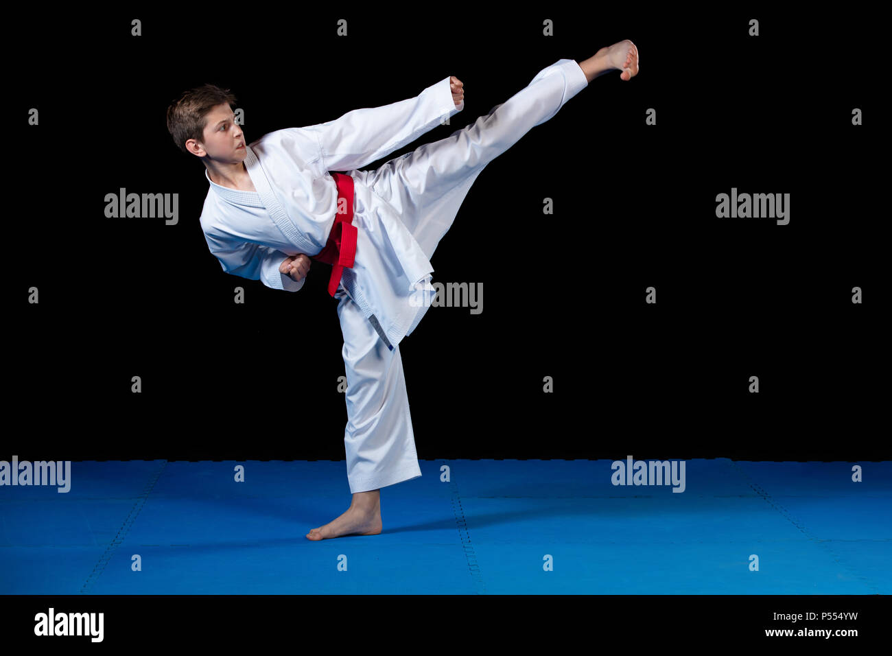 Young boy dressed in a white karate kimono with red belt Stock Photo