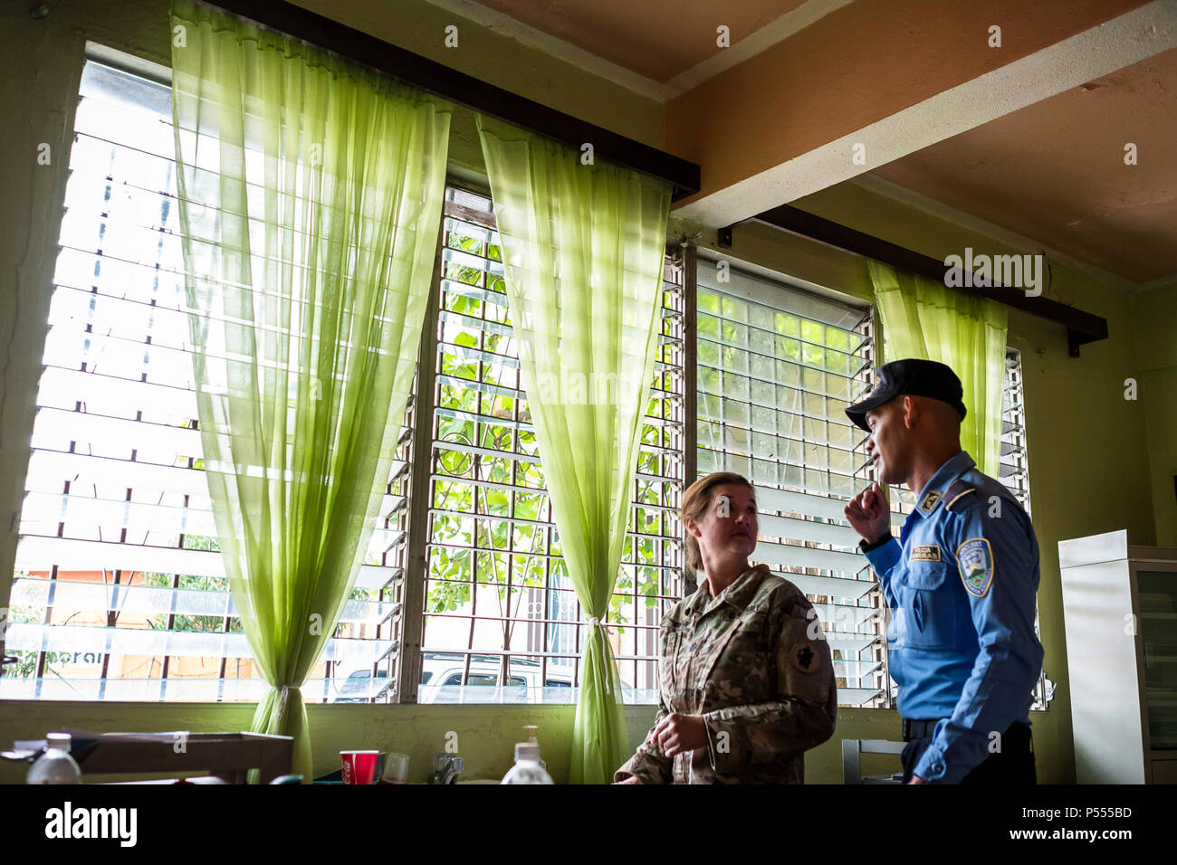 U.S. Army Lt. Col. Rhonda Dyer, Joint Task Force – Bravo Medical Element, speaks with a Honduran Police National about the Community Health Nurse mission in Comayagua, Honduras, May 10, 2017. The CHM is a weekly partnership with the staff at Jose Ochoa Public Health Clinic, administering vaccines, Vitamins, deworming medication and other medical supplies to over 180 Hondurans around the Comayagua area on May 10, 2017. Stock Photo
