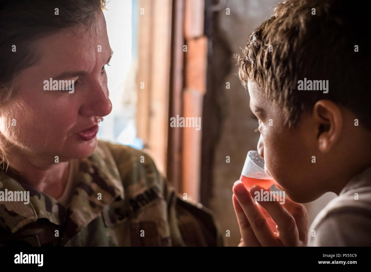 U.S. Army Lt. Col. Rhonda Dyer, Joint Task Force - Bravo, gives deworming medication to a local Honduran child while out on a Community Health Nurse mission in Comayagua, Honduras, May 10, 2017. The CHM is a weekly partnership with the staff at Jose Ochoa Public Health Clinic, administering vaccines, Vitamins, deworming medication and other medical supplies to over 180 Hondurans around the Comayagua area on May 10, 2017. Stock Photo