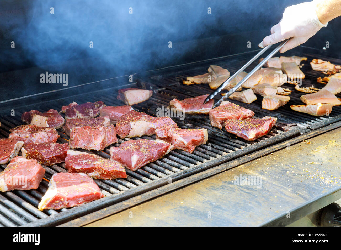 Steaks seasoned with salt and pepper on an outdoor grill Stock Photo