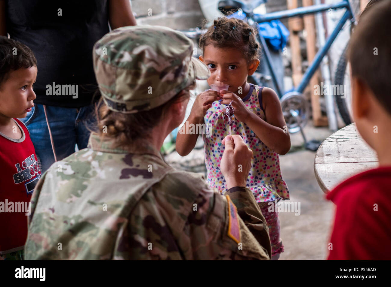 U.S. Army Lt. Col. Rhonda Dyer, Joint Task Force - Bravo, gives deworming medication to a local Honduran child while out on a Community Health Nurse mission in Comayagua, Honduras, May 10, 2017. The CHM is a weekly partnership with the staff at Jose Ochoa Public Health Clinic, administering vaccines, Vitamins, deworming medication and other medical supplies to over 180 Hondurans around the Comayagua area on May 10, 2017. Stock Photo