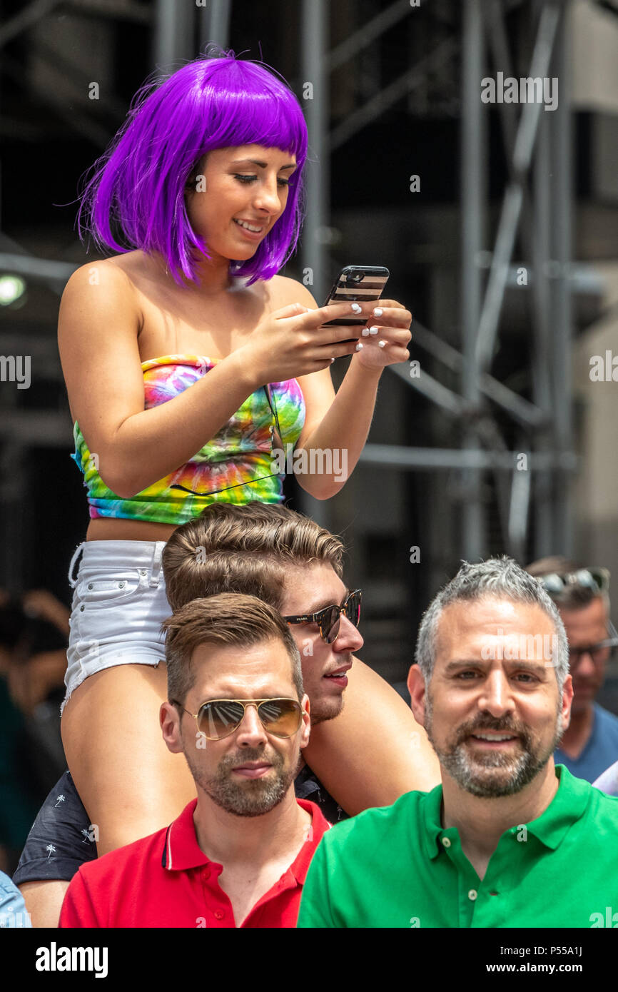 New York, USA, 24 June 2018. A woman with a purple wig works her phone while watching the New York City Pride Parade 2018.  Photo by Enrique Shore Credit: Enrique Shore/Alamy Live News Stock Photo