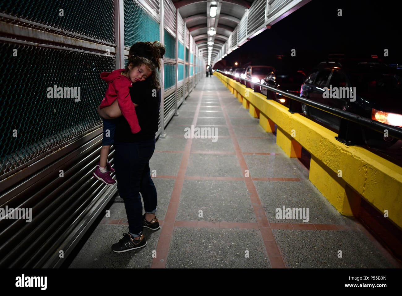 Brownsville, Texas, USA. 24th June, 2018. Paola, 18, a Honduran woman, and her baby carol, 2, arrive Sunday night at the bridge connecting Matamoros, Mexico to Brownsville, Texas, the last part of a journey that began two months ago in Tegusigalpa, Honduras. As the Trump administration scrambled to deal with an immigration crisis on the border, a continuous stream of migrants are arriving every day. Credit: Miguel Juarez Lugo/ZUMA Wire/Alamy Live News Stock Photo