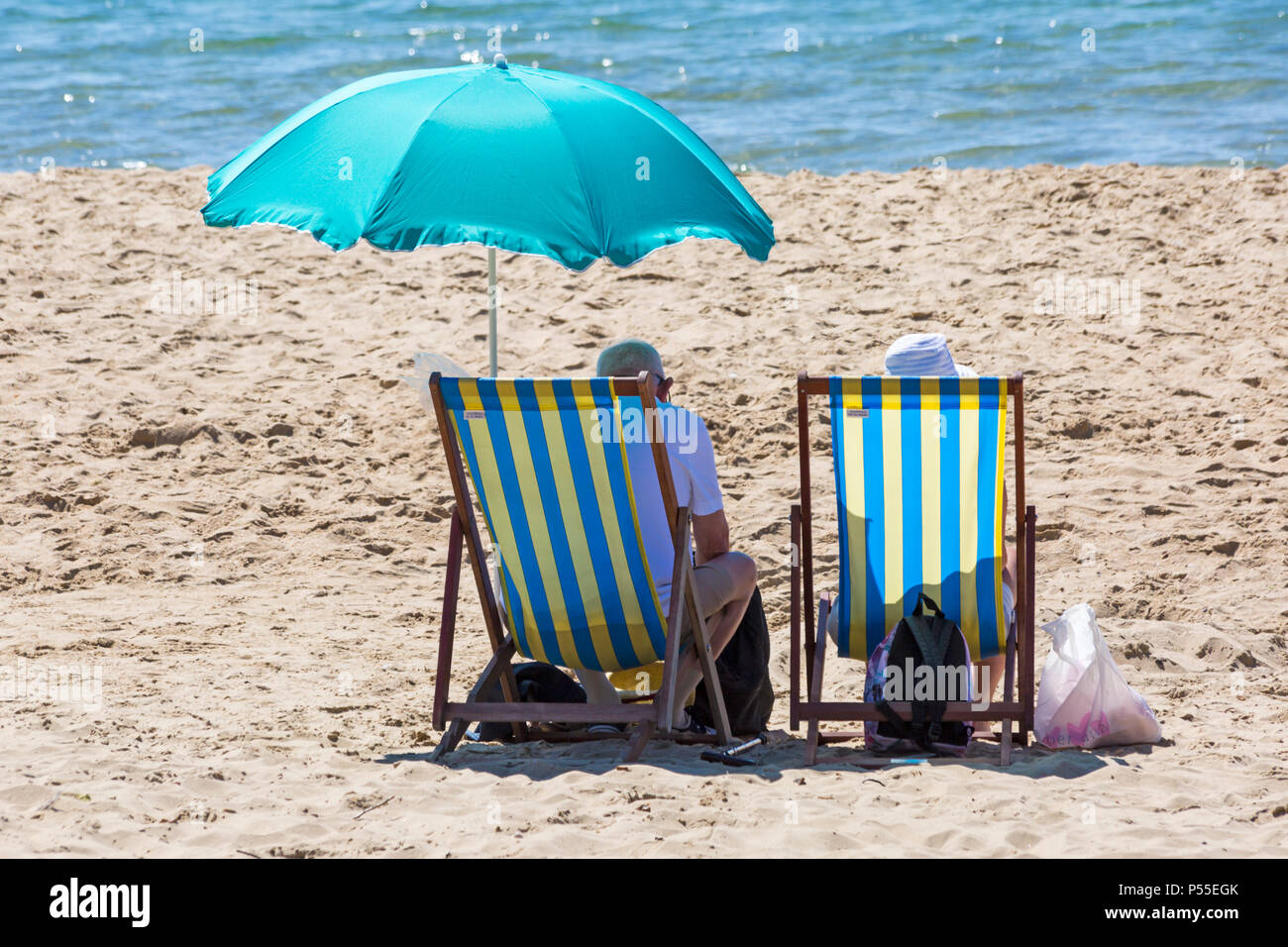 Couple sitting on beach under parasol hi-res stock photography and images -  Alamy