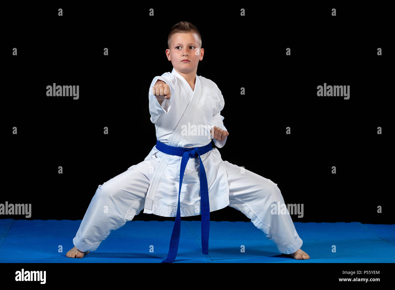 Pre-teen boy doing karate on a black background Stock Photo