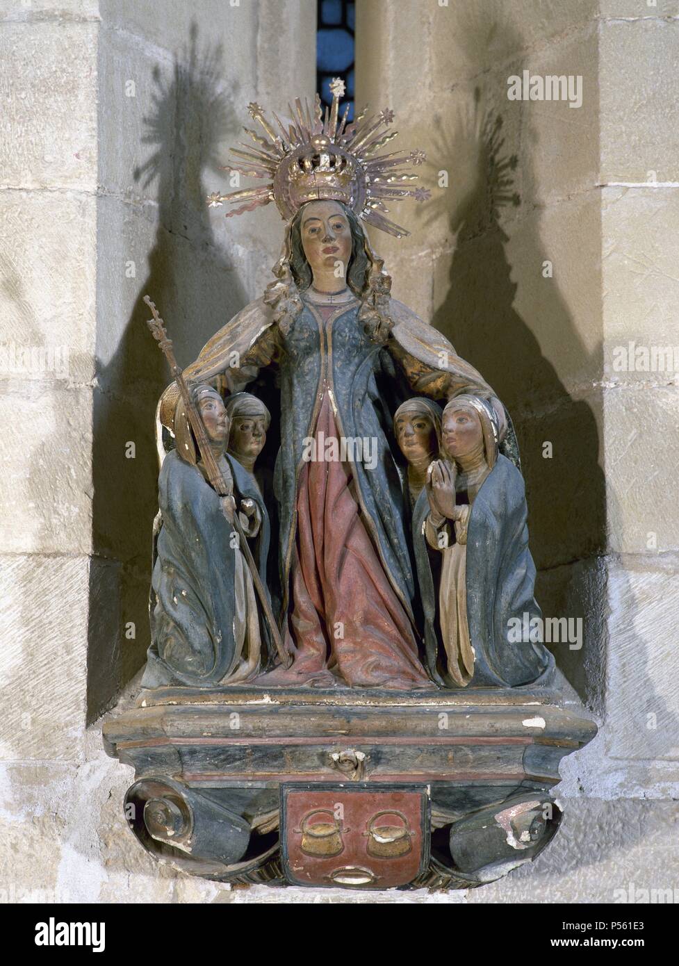 ARTE GOTICO. ESPAÑA. JOHAN, Pere (h.1396-h.1458). Escultor catalán. 'GRUPO DE LA VIRGEN DE LA MISERICORDIA'. Formado por la Vírgen y cuatro monjas bernardinas, arrodilladas bajo su manto, una de ellas sosteniendo el báculo abacial. En su base, el escudo de la abadesa Blanca deCaldes (1420-1446). Terracota policromada (1426-1430). Sala Capitular Monasterio de Santa Maria de Vallbona de les Monges. Stock Photo