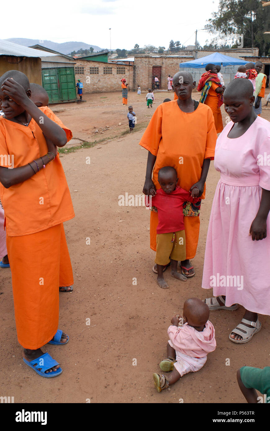 RWANDA, Gitarama , jail with 7500 prisoner , mostly for Hutu for genocide crimes , many detainees are  women with children, prisoner in orange clothes: already sentenced, pink clothes: waiting for accusation / RUANDA, Gitarama , Gefaengnis mit 7500 Haeftlingen , viele sind Hutu und wegen Genozid Verbrechen inhaftiert , darunter auch viele Frauen mit Kindern , Haeftlingskleidung orange: bereits verurteilt , rosa: warten auf Anklage Stock Photo