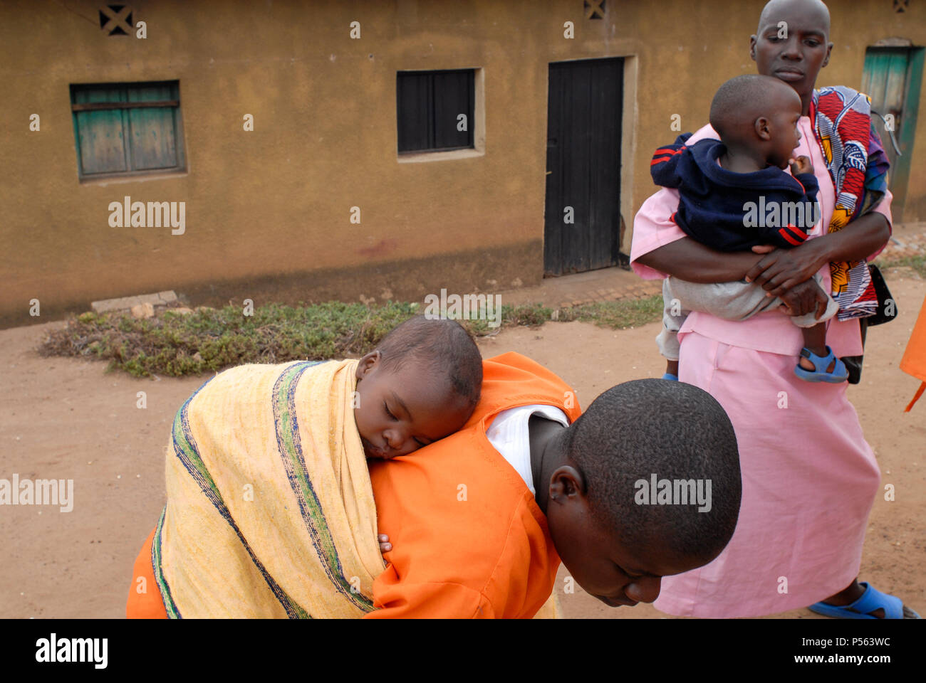 RWANDA, Gitarama , jail with 7500 prisoner , mostly for Hutu for genocide crimes , many detainees are  women with children, prisoner in orange clothes: already sentenced, pink clothes: waiting for accusation / RUANDA, Gitarama , Gefaengnis mit 7500 Haeftlingen , viele sind Hutu und wegen Genozid Verbrechen inhaftiert , darunter auch viele Frauen mit Kindern , Haeftlingskleidung orange: bereits verurteilt , rosa: warten auf Anklage Stock Photo