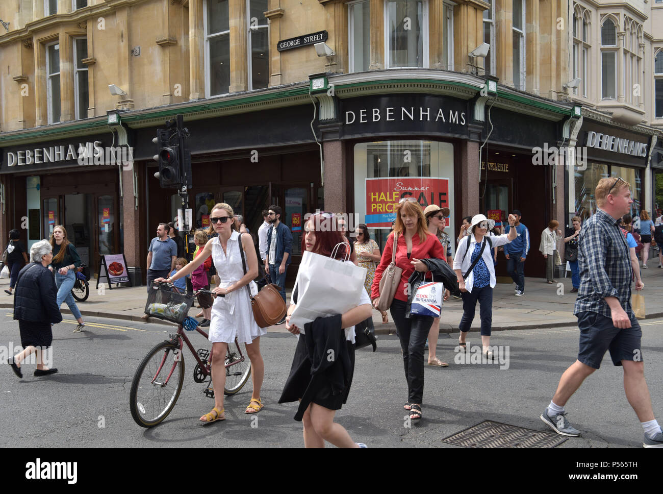 Shoppers and tourists walk past the department store Debenhams on the corner of the high street, George Street in Oxford Stock Photo