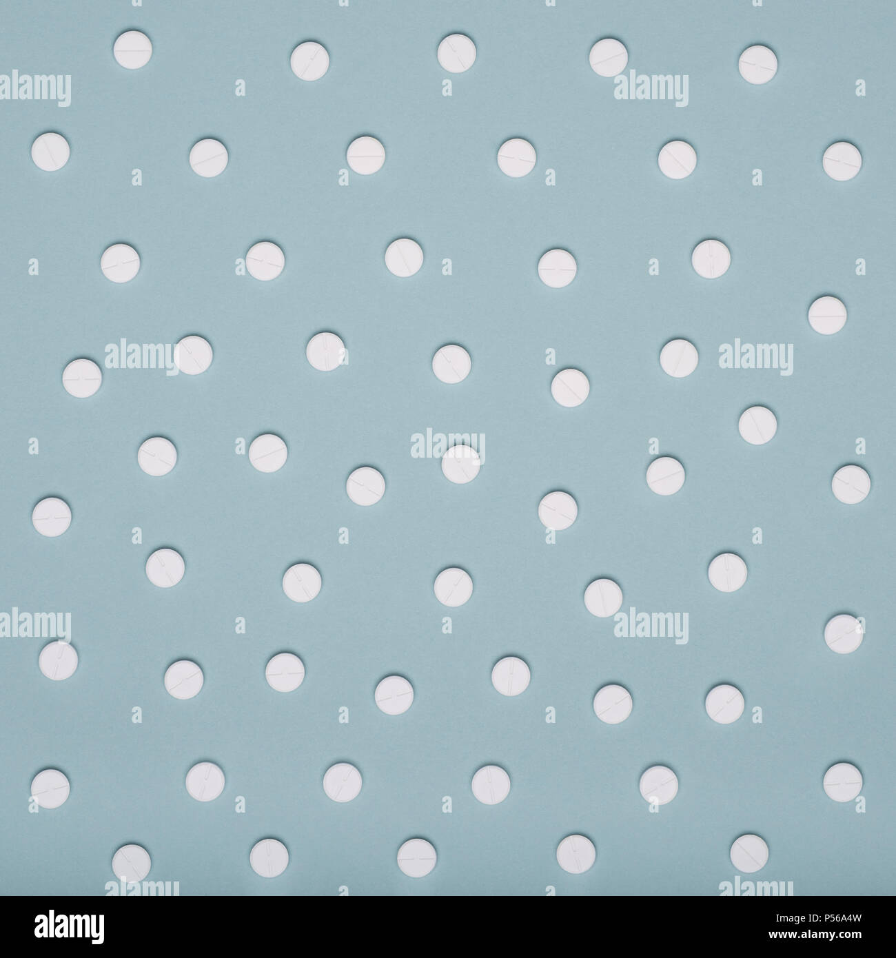 White pills on blue pastel colored background. Medication and prescription pills minimal background. Stock Photo