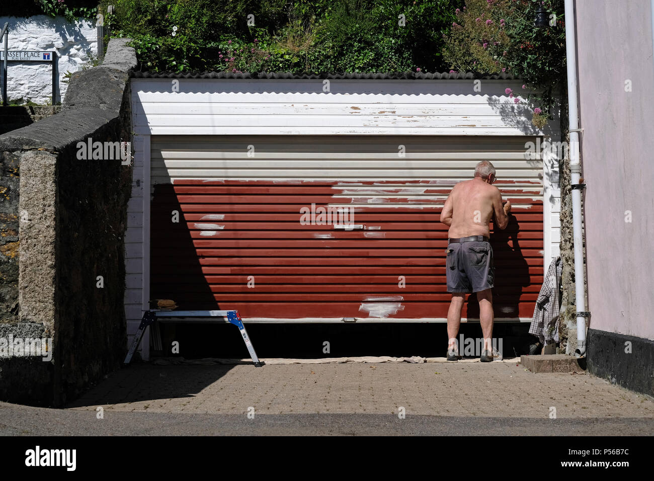 An old man painting a garage door Stock Photo
