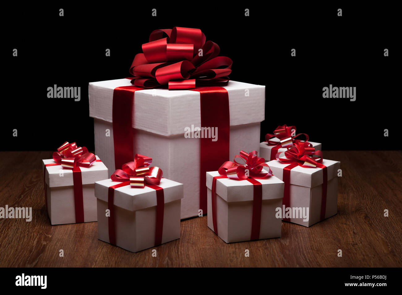 one large white gift box with small gift boxes on black background