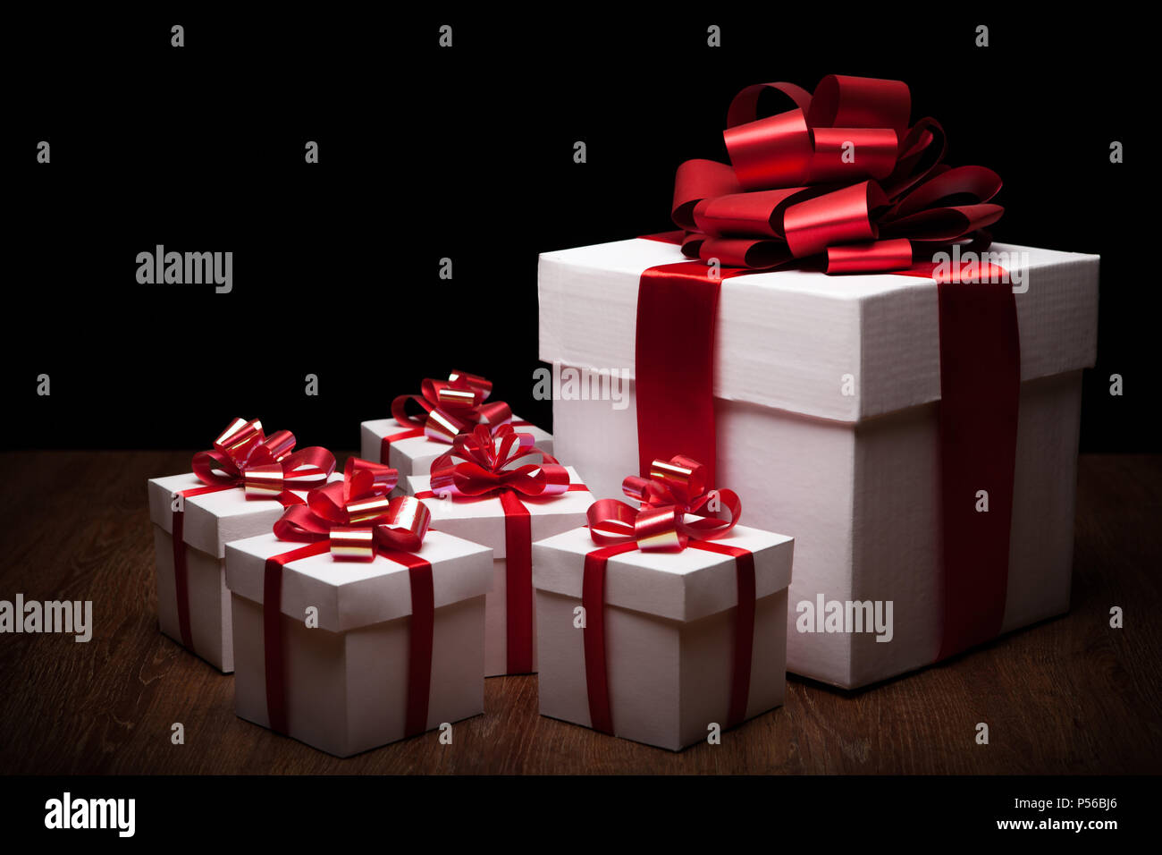 one large white gift box with small gift boxes on black background Stock  Photo - Alamy