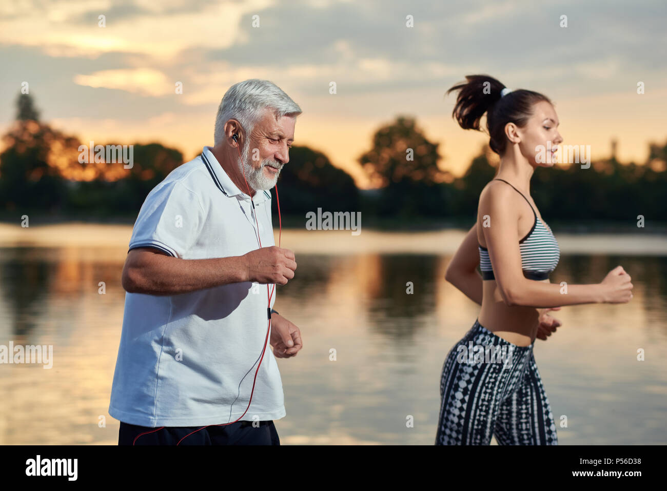 Senior and young generations evening's workout on fresh air. Outdoor activities, healthy lifestyle, strong bodies, fit figures. Stylish, modern sportswear. Different generations. Sport, yoga, fitness Stock Photo