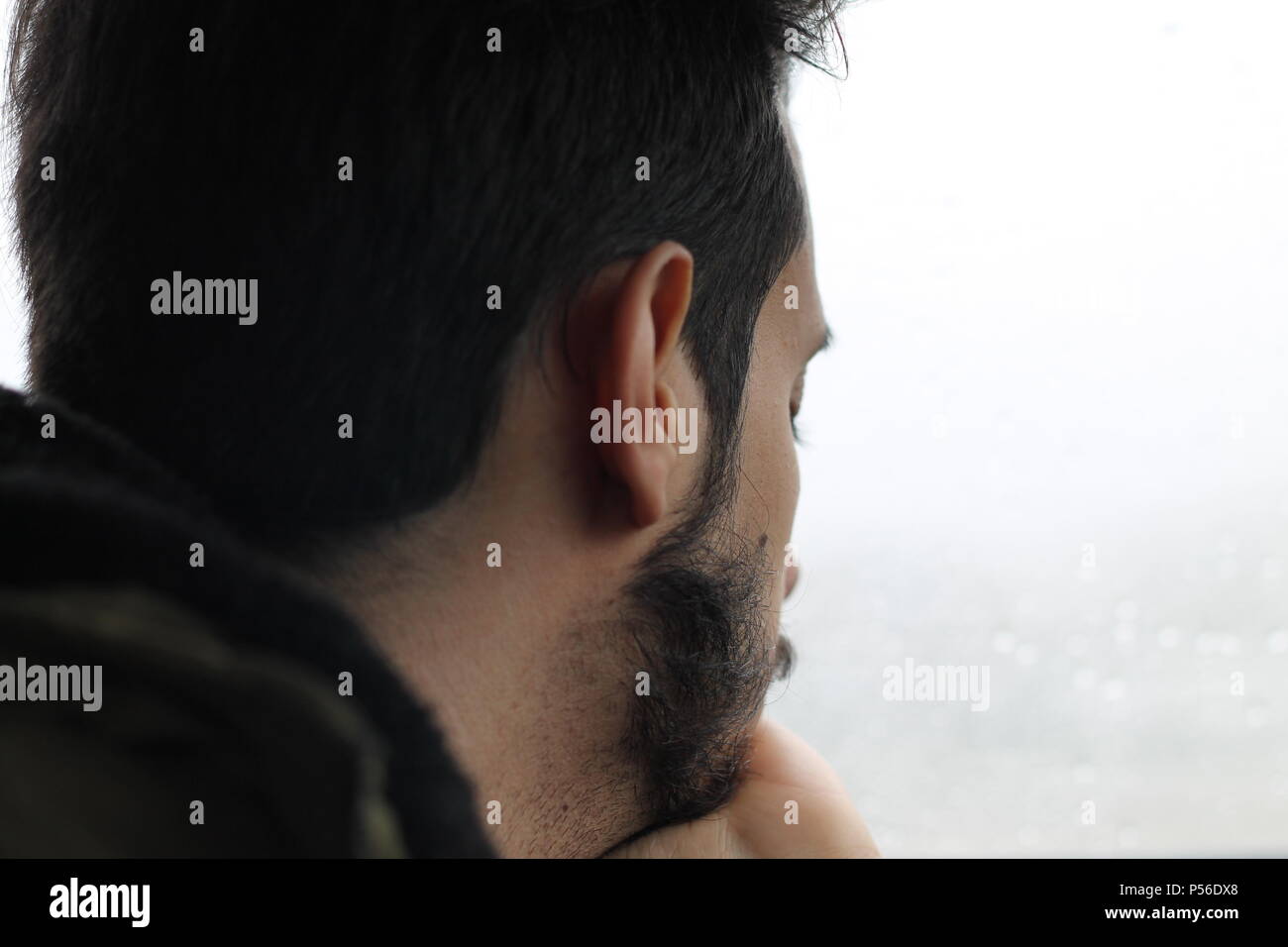 Young men thinking with his hand on chin. Looking upset or sad. Stock Photo