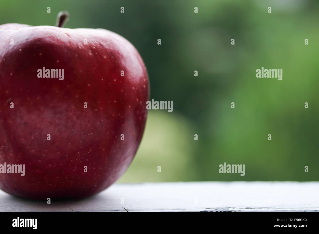Red apple on a green background Stock Photo - Alamy