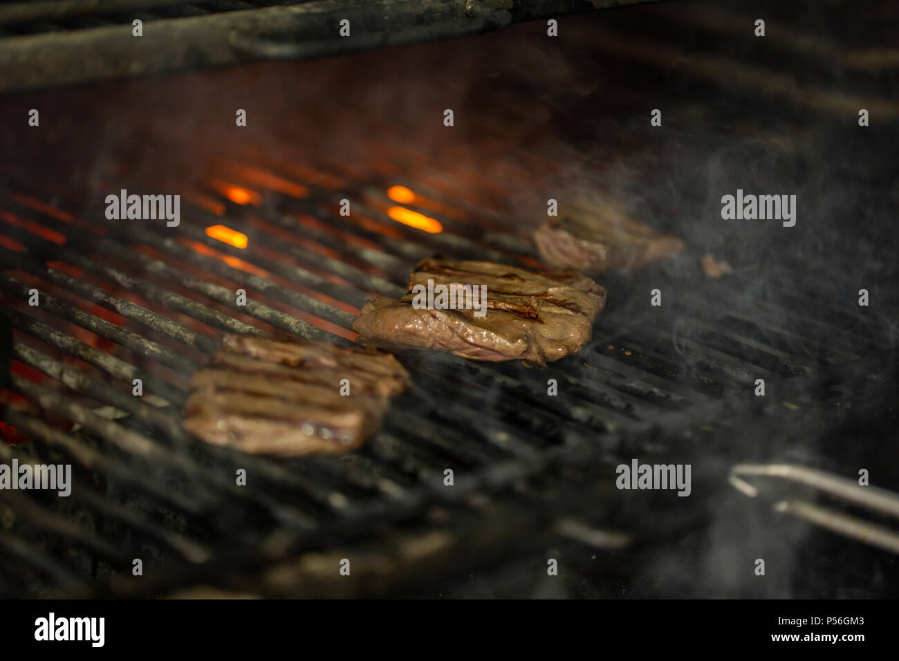 A top sirloin steak flame broiled on a barbecue, shallow depth of field