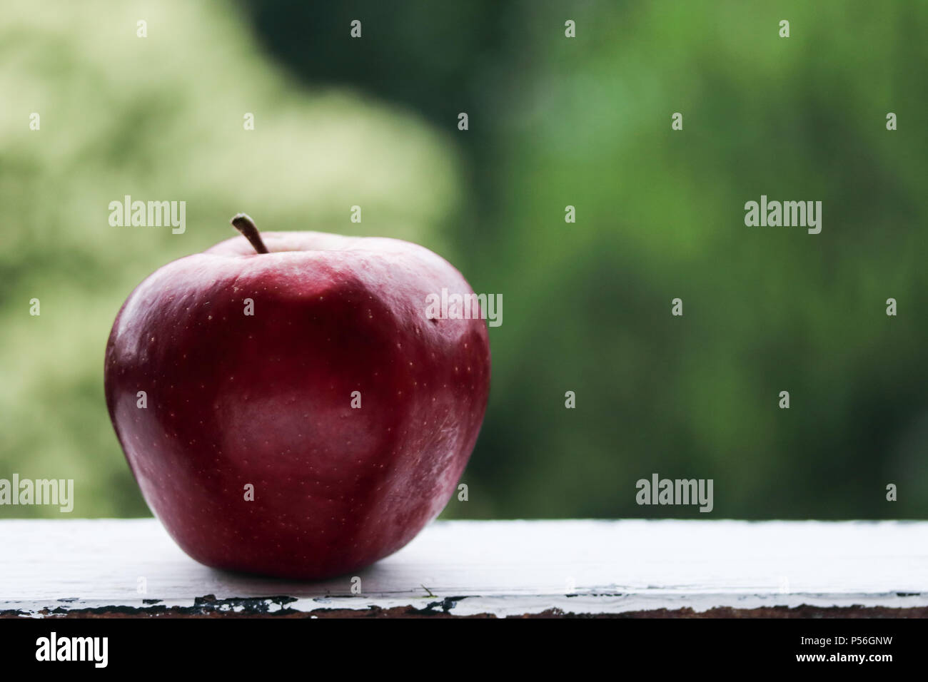 Red apple on a green background Stock Photo - Alamy