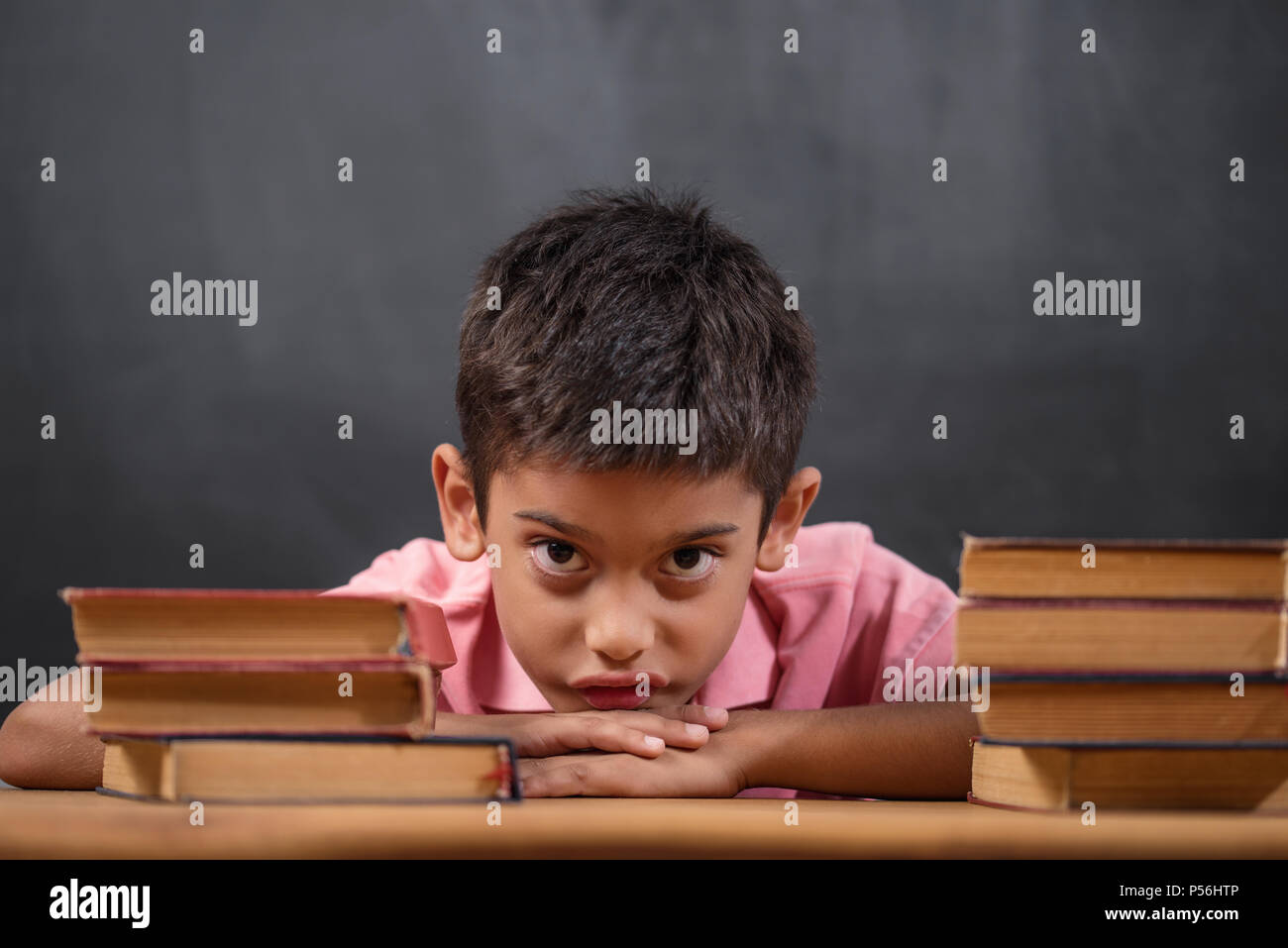 Thoughtful cute clever boy with book on table. First time to school. Back to school Stock Photo