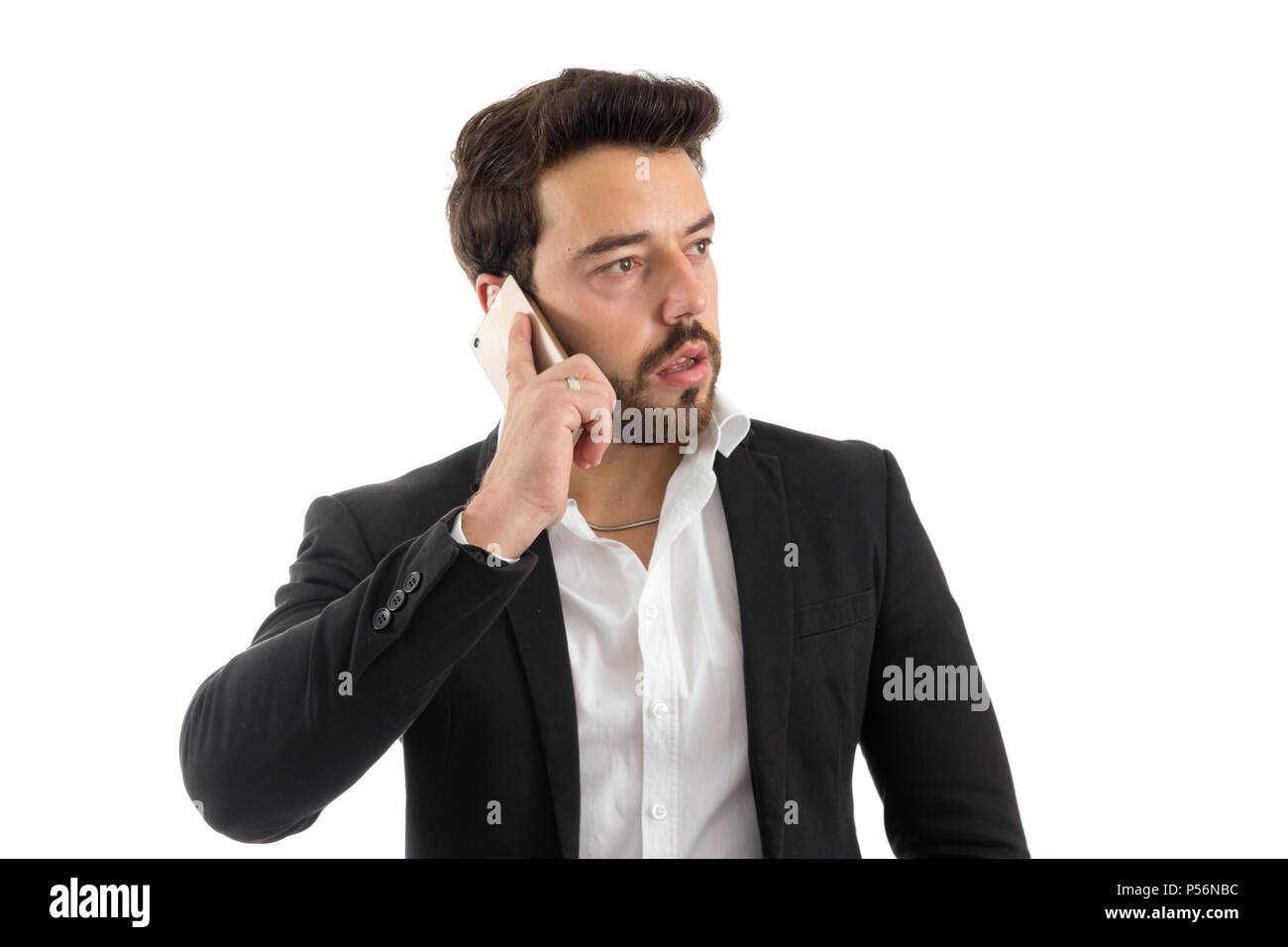 Businessman is looking to the side. He's talking on the phone. Concept of communication, telephony. Beautiful bearded person is wearing black jacket a Stock Photo