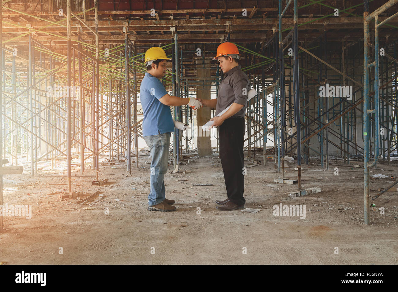 Engineer discussing with foreman about project in building construction site Stock Photo