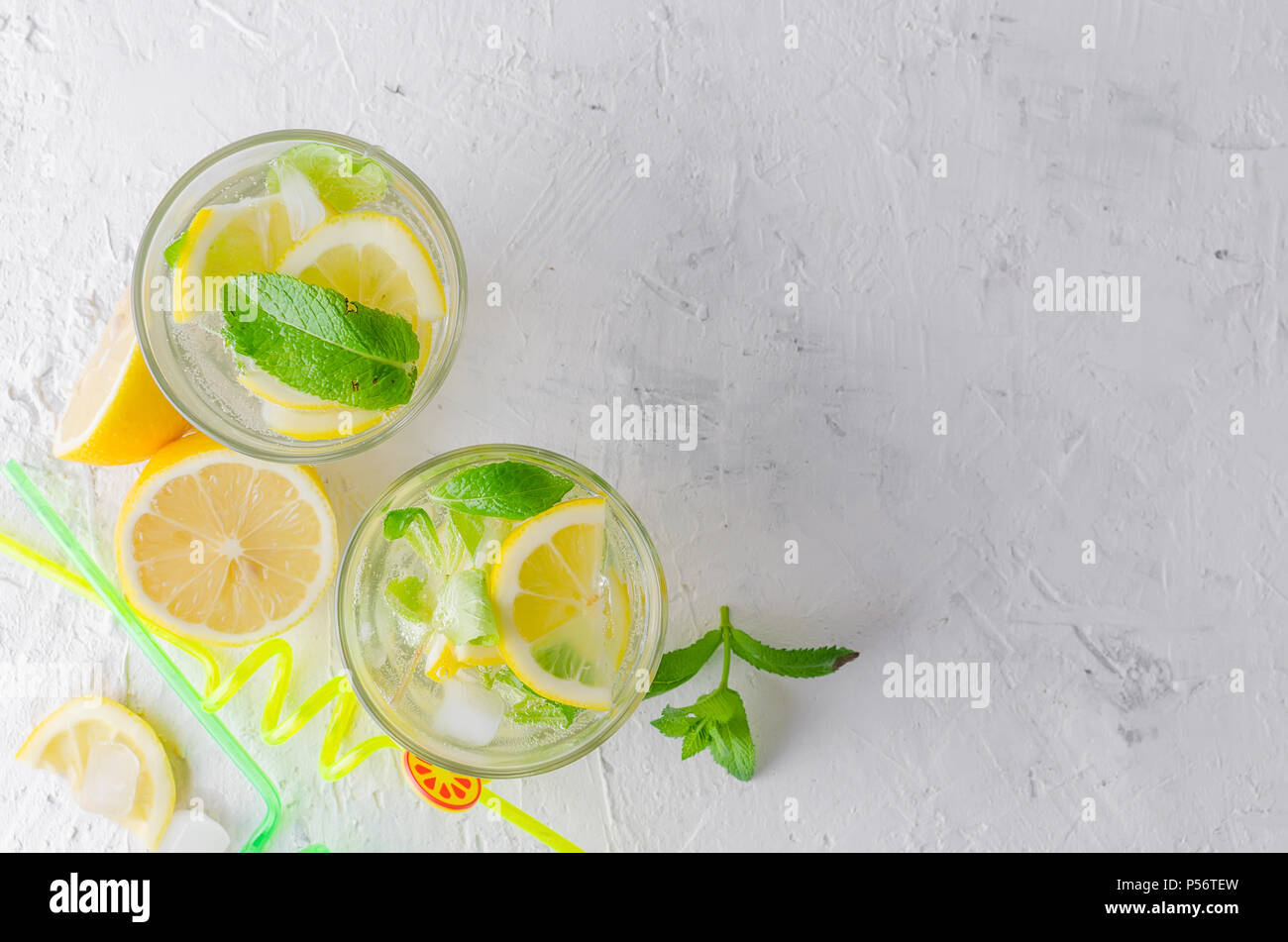 Fresh cold Mojito Cocktail with soda and lemon in glass and ingredients on a light background Stock Photo