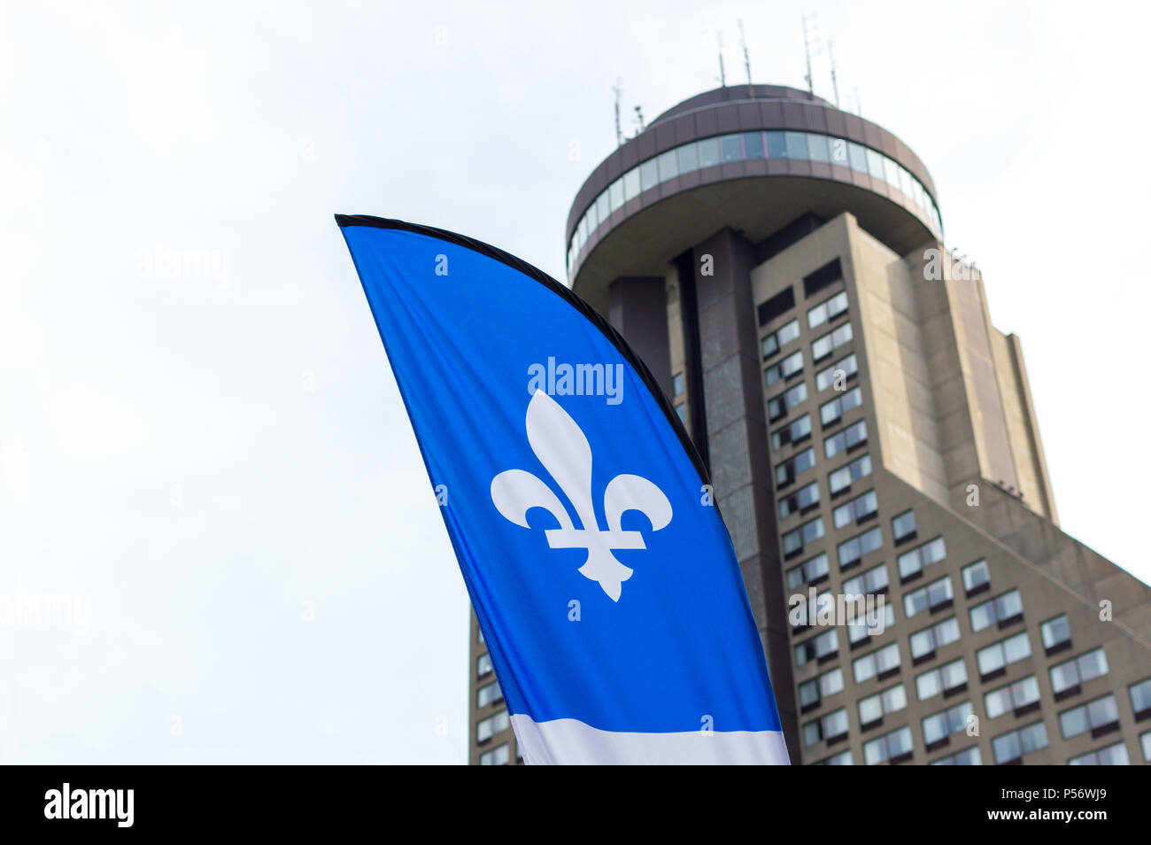 Quebec City, Quebec, Canada - June 23,  2018: Quebec flag and Hotel Le Concorde view in summer sunny blue sky Stock Photo