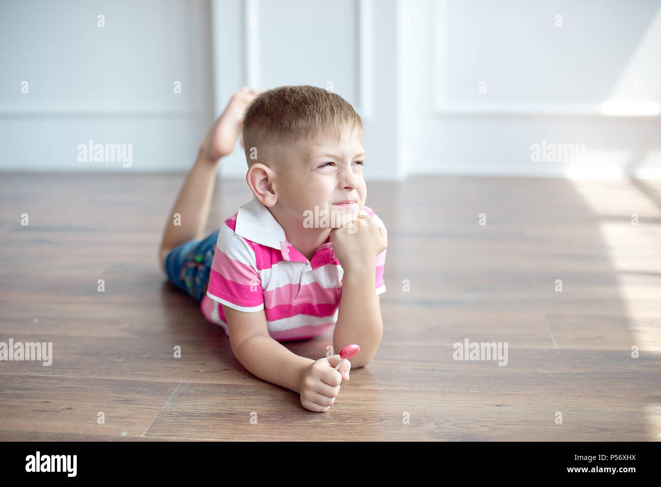 Little Cute Boy With Modern Haircut Sitting On The Floor In Big