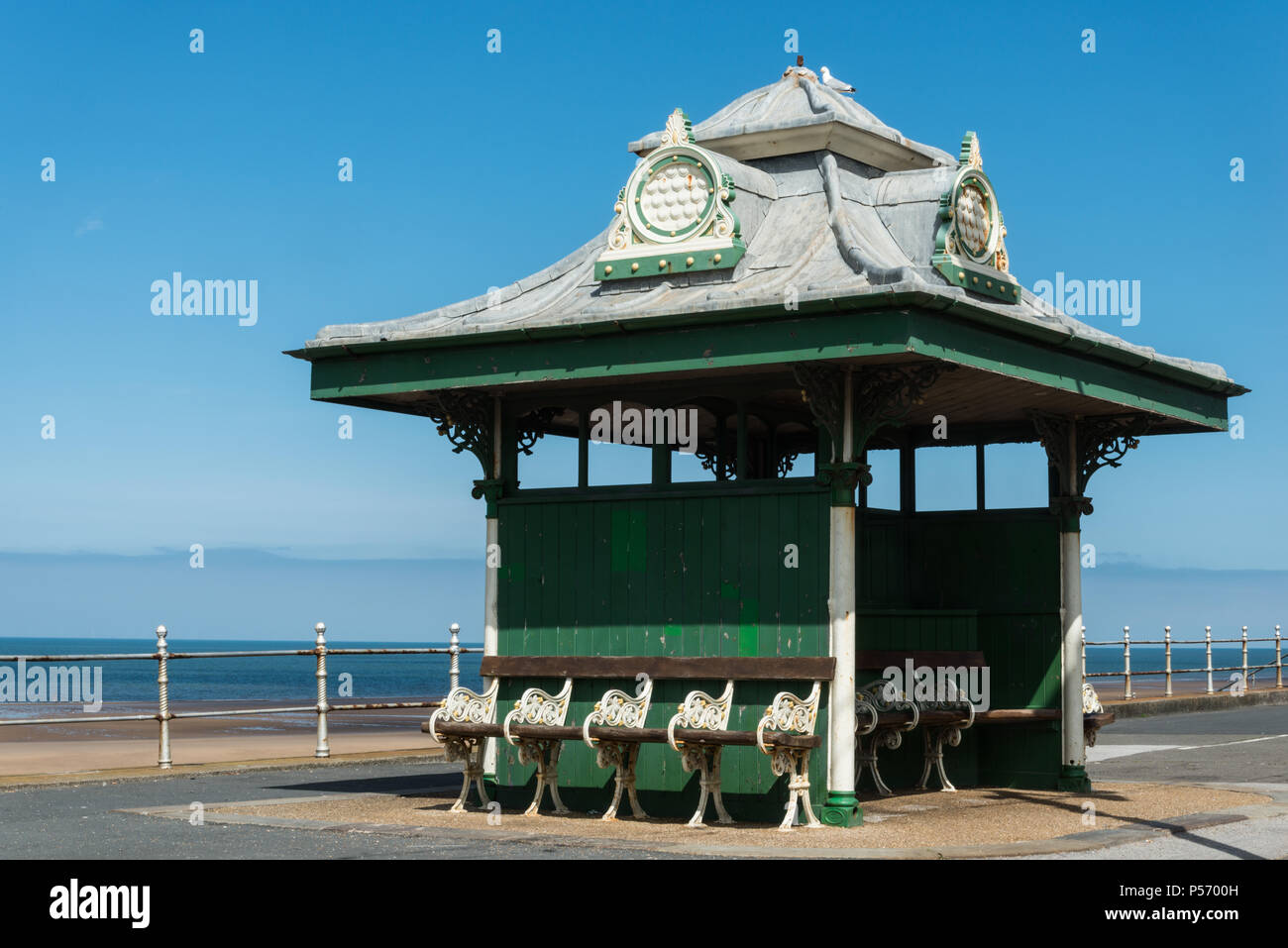 Historical green coastal shelters with benches on the promenade of the tourist resort of Blackpool, Lancashire, England, UK Stock Photo