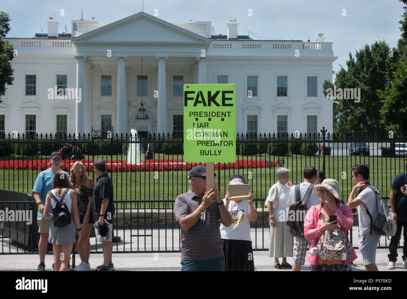 Anti-Trump Picket at White House; placard indicating President Trump's characteristics: liar, con man, predator, bully. June 25, 2017. Tourists nearby Stock Photo