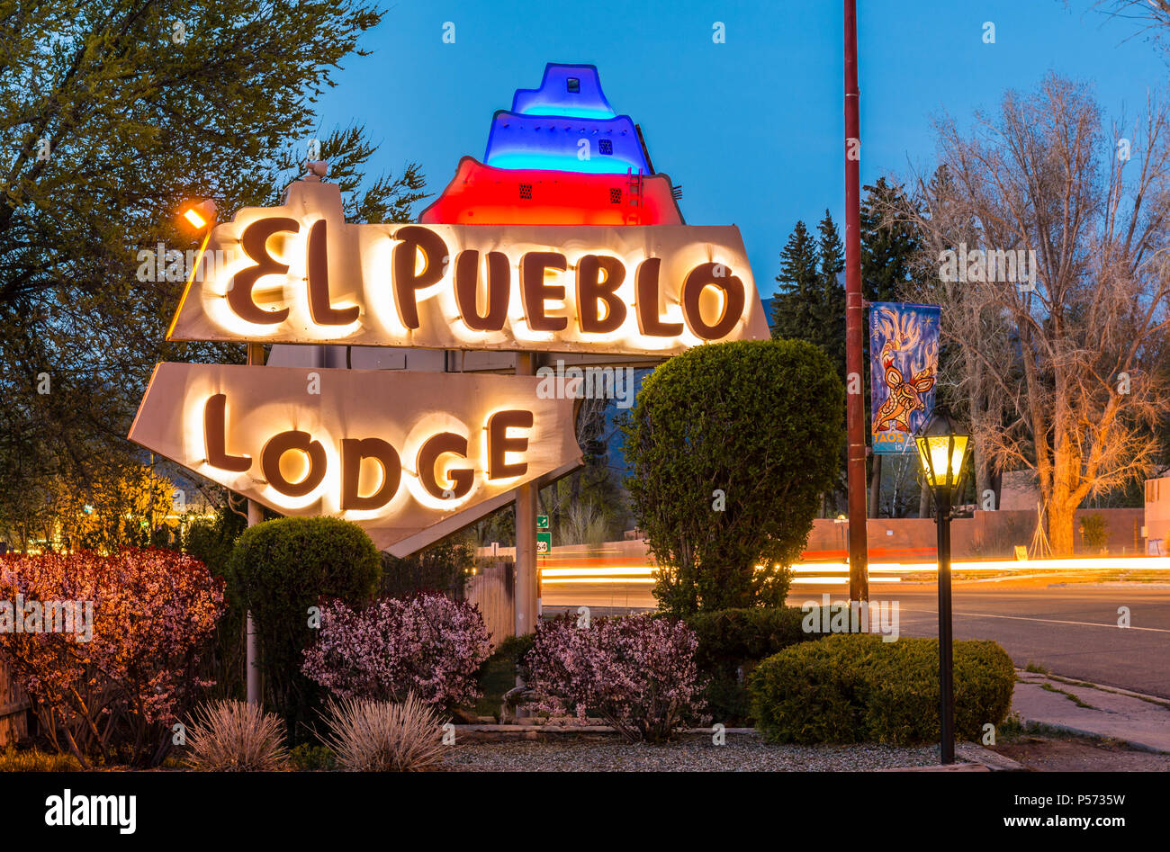 El Pueblo Lodge vintage, retro neon sign at night with traffic light streaks in Taos, New Mexico USA. Stock Photo