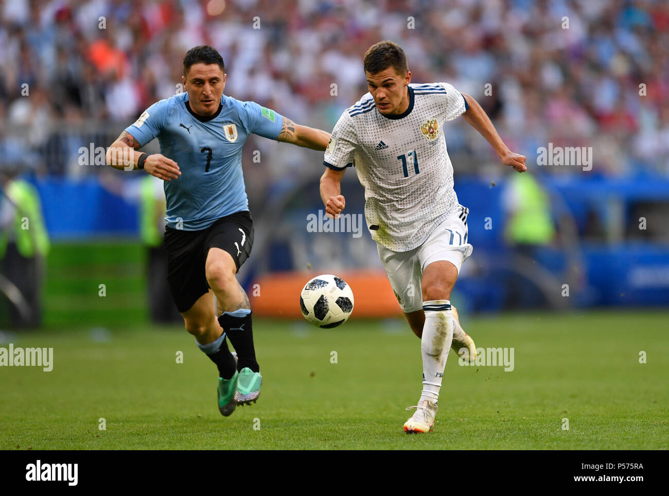 Samara, Russia. 25th June, 2018. Soccer: World Cup, group stages, group A, 3rd matchday Uruguay vs Russia, at Samara Stadium. Russia's Roman Zobnin (R) and Uruguay's Cristian Rodriguez vie for the ball. Credit: Marius Becker/dpa/Alamy Live News Stock Photo