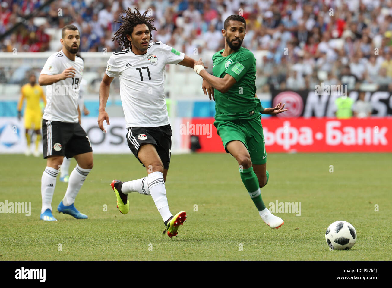 Volgograd, Russia. 25th June, 2018. Egypt's Mohamed Elneny (L) battles for the ball with Saudi Arabia's Salman Al-Faraj (C) during the FIFA World Cup 2018 Group A soccer match between Saudi Arabia and Egypt at the Volgograd Arena in Volgograd, Russia, 25 June 2018. Credit: Ahmed Ramadan/dpa/Alamy Live News Stock Photo