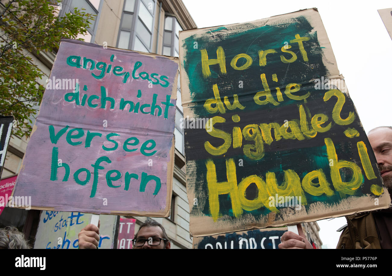 Berlin, Germany. 25th June, 2018. Protestors carrying signs that read 'Horst du die Signale? Hau ab!' (lit. do you here the signals? get out!; play on words, Horst and hoerst) and 'Angie lass dich nicht verseehofern' (lit. Angie do not be fooled; play on words with Seehofer) stand outside the Bavarian state representation. More than 200 people protest against the planned refugee policy of Seehofer, German Minister of the Interior, Homeland and Building. Credit: Paul Zinken/dpa/Alamy Live News Stock Photo