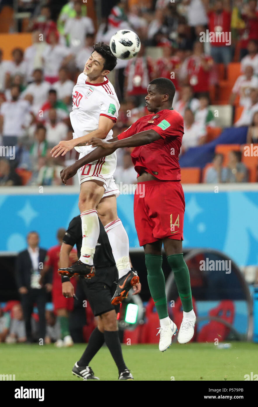 Saransk, Russia. 25th June, 2018. William Carvalho (R) of Portugal competes for a header with Sardar Azmoun of Iran during the 2018 FIFA World Cup Group B match between Iran and Portugal in Saransk, Russia, June 25, 2018. The match ended in a 1-1 draw. Portugal advanced to the round of 16. Credit: Ye Pingfan/Xinhua/Alamy Live News Stock Photo