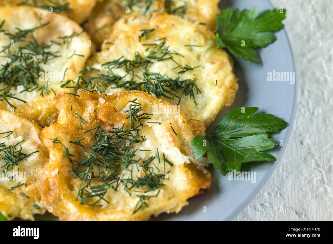 Roasted (fried) slices zucchini in egg batter with garlic Stock Photo