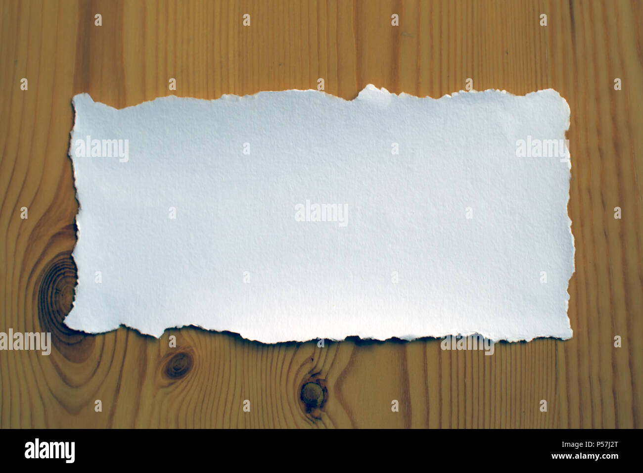 White sheet of paper on a wooden background for love notes and invitation cards Stock Photo