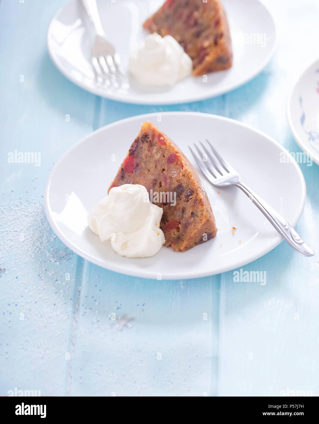 Christmas pudding served with dollop of whipped cream Stock Photo