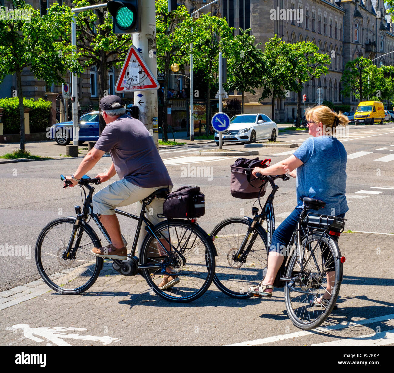 Strasbourg, mature couple of cyclists waiting at traffic light before crossing the street, Alsace, France, Europe, Stock Photo