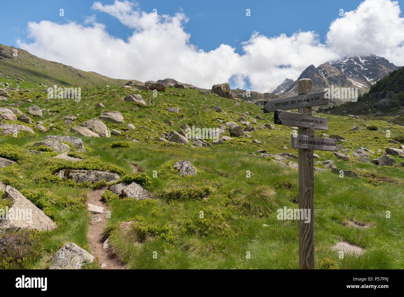 Wooden fingerpost in the French Pyrenees pointing along a footpath to the Refuge du Rulhe, Laparin and the Etangs de Fontargente, on the GR10 route. Stock Photo