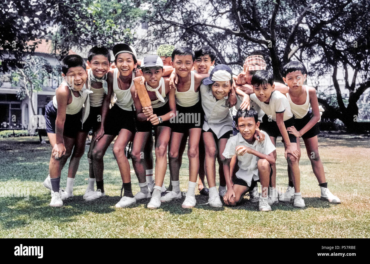 Twelve young schoolboys take a break from playing games to pose for a group photo in Singapore, a multiracial and multicultural Southeast Asian country with ethnic Chinese, Indians, and Malays making up the majority of the population. Stock Photo