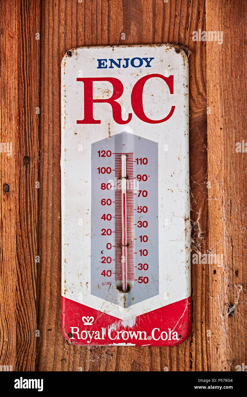 Vintage or antique Royal Crown Cola (RC Cola) thermometer advertising the soda drink on an old cabin wall in rural Alabama. Stock Photo