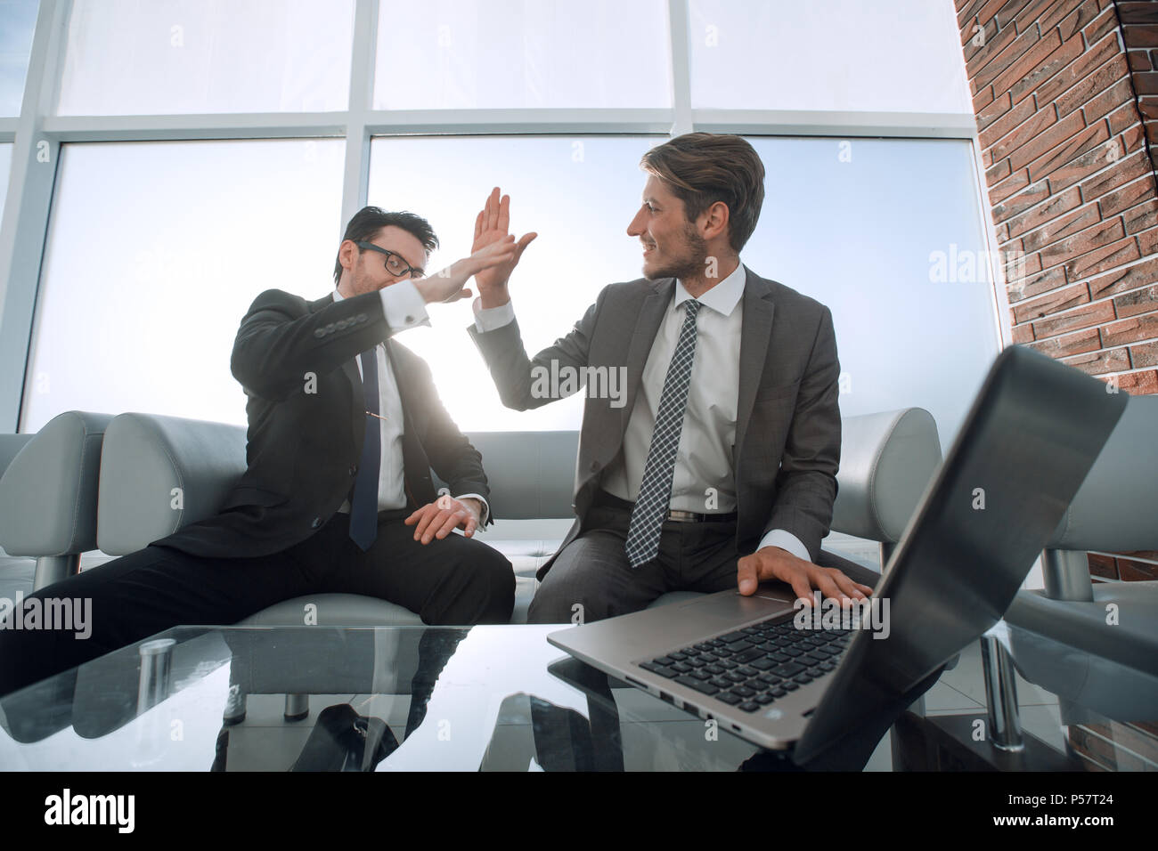 two businessmen giving each other a high five Stock Photo - Alamy