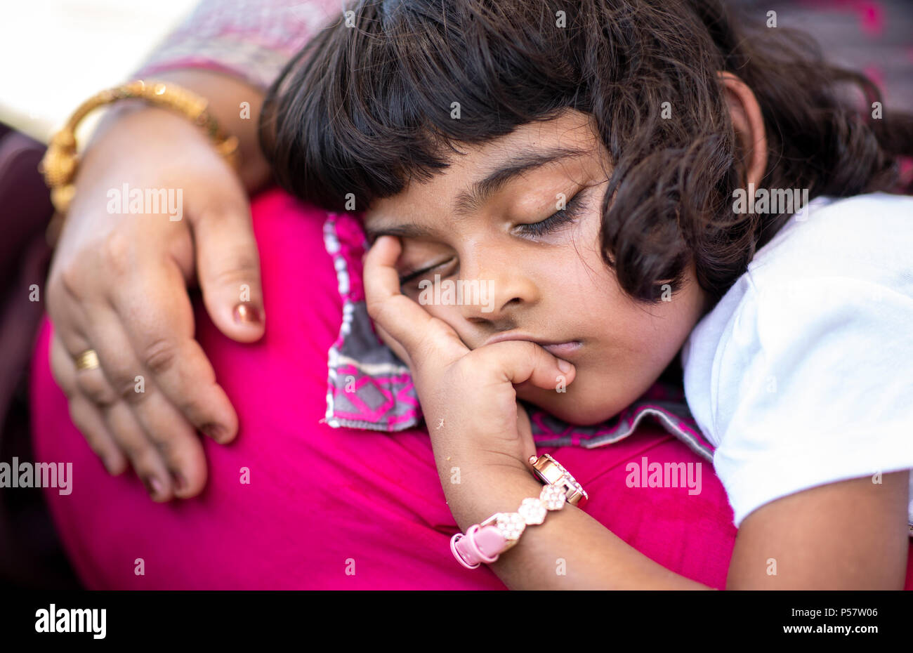 Khasab, Musandam, 22nd, June 2018: little pakistani girl fallen asleep on her mothers lap Stock Photo