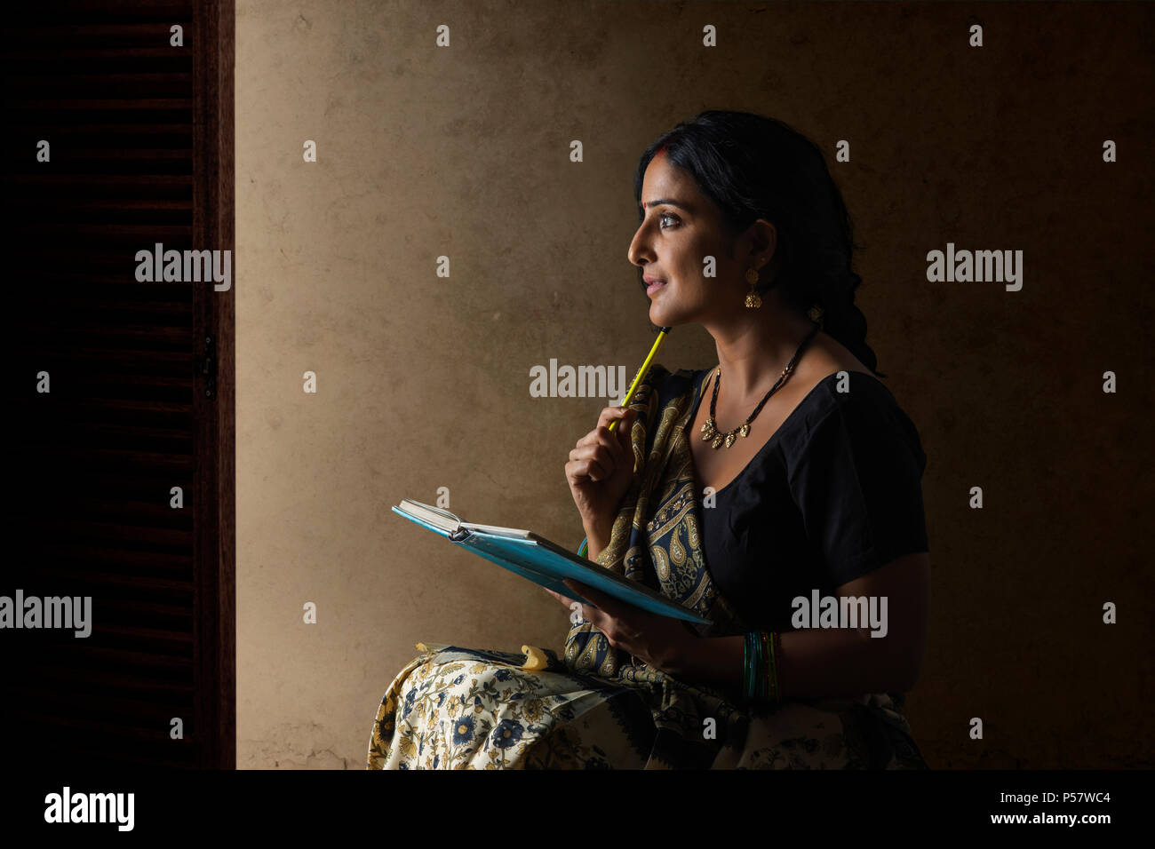 Woman thinking holding pencil hi-res stock photography and images - Alamy