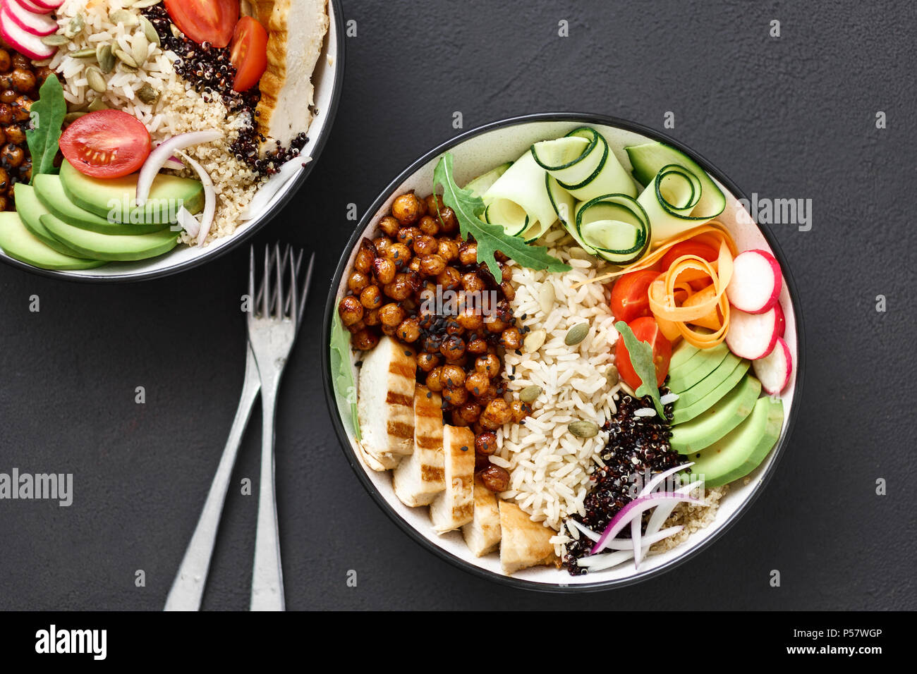 Healthy clean and balanced eating concept. Chicken grilled steak, rice, spicy chickpeas, black and white quinoa, avocado, carrot, zucchini, radish, to Stock Photo