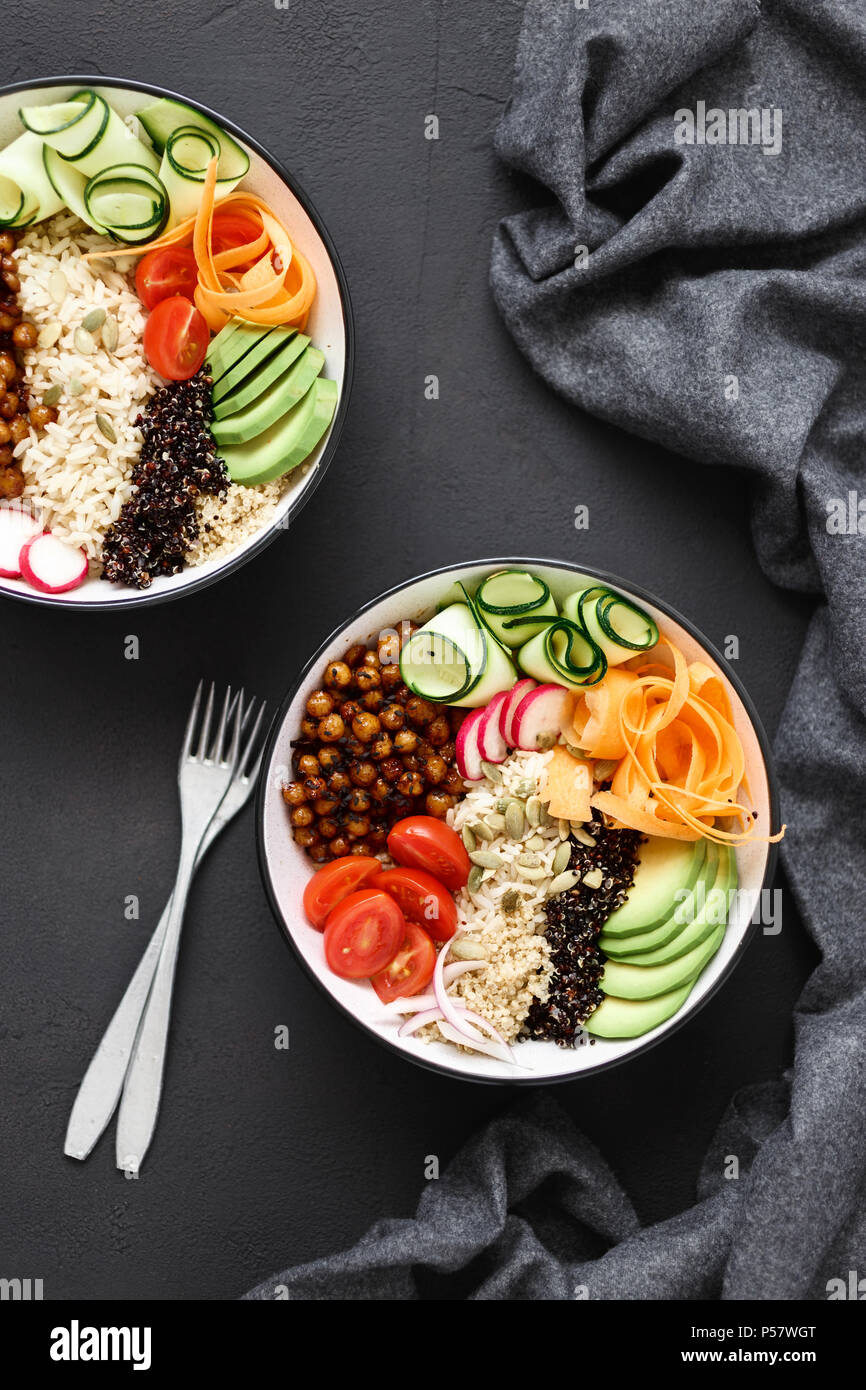 Two vegetarian buddha bowl. Clean and balanced healthy food concept. Rice, spicy chickpeas, black and white quinoa, avocado, carrot, zucchini, radish, Stock Photo