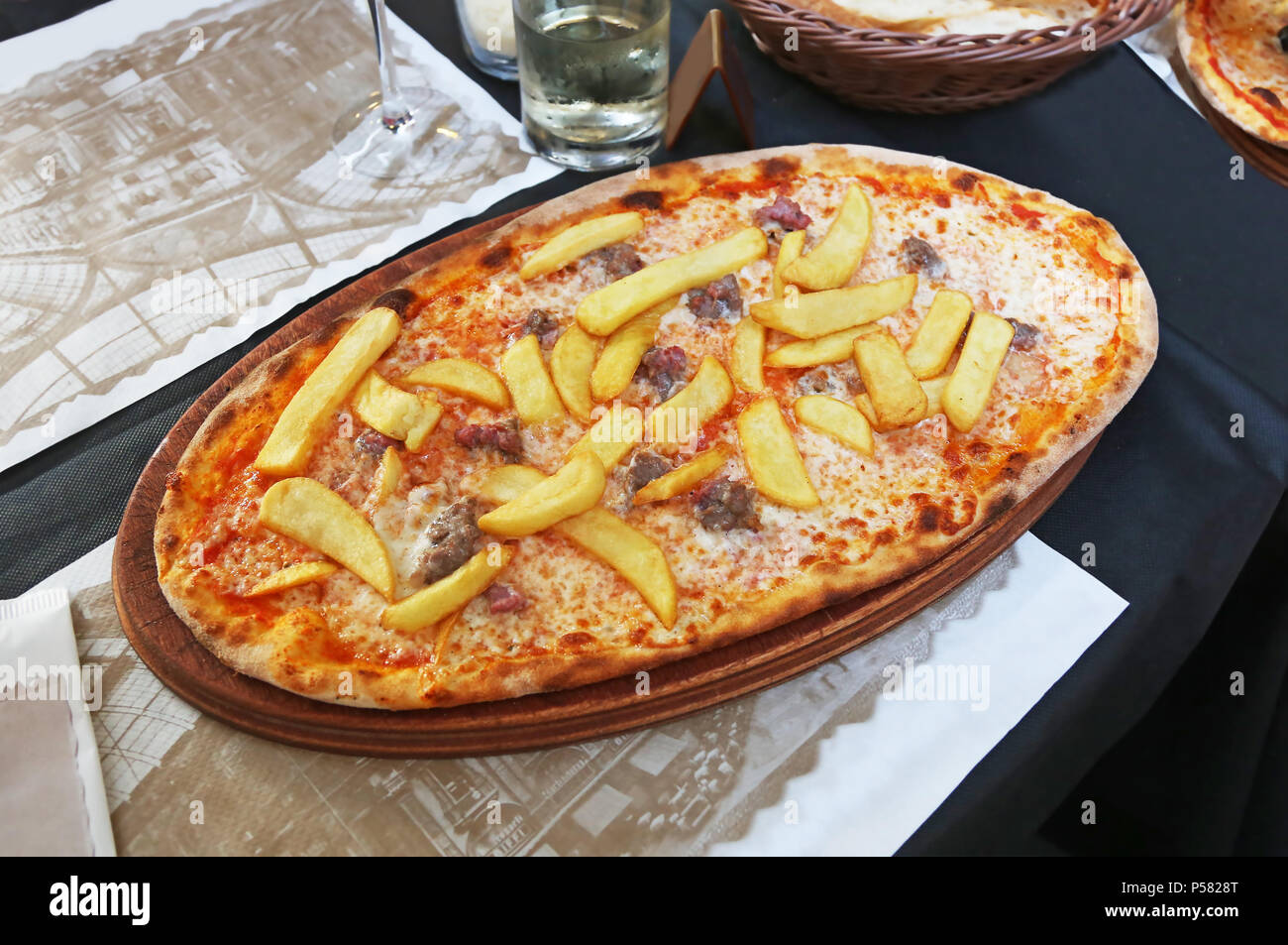 traditional italian pizza with potato fries, sausages, cheese and