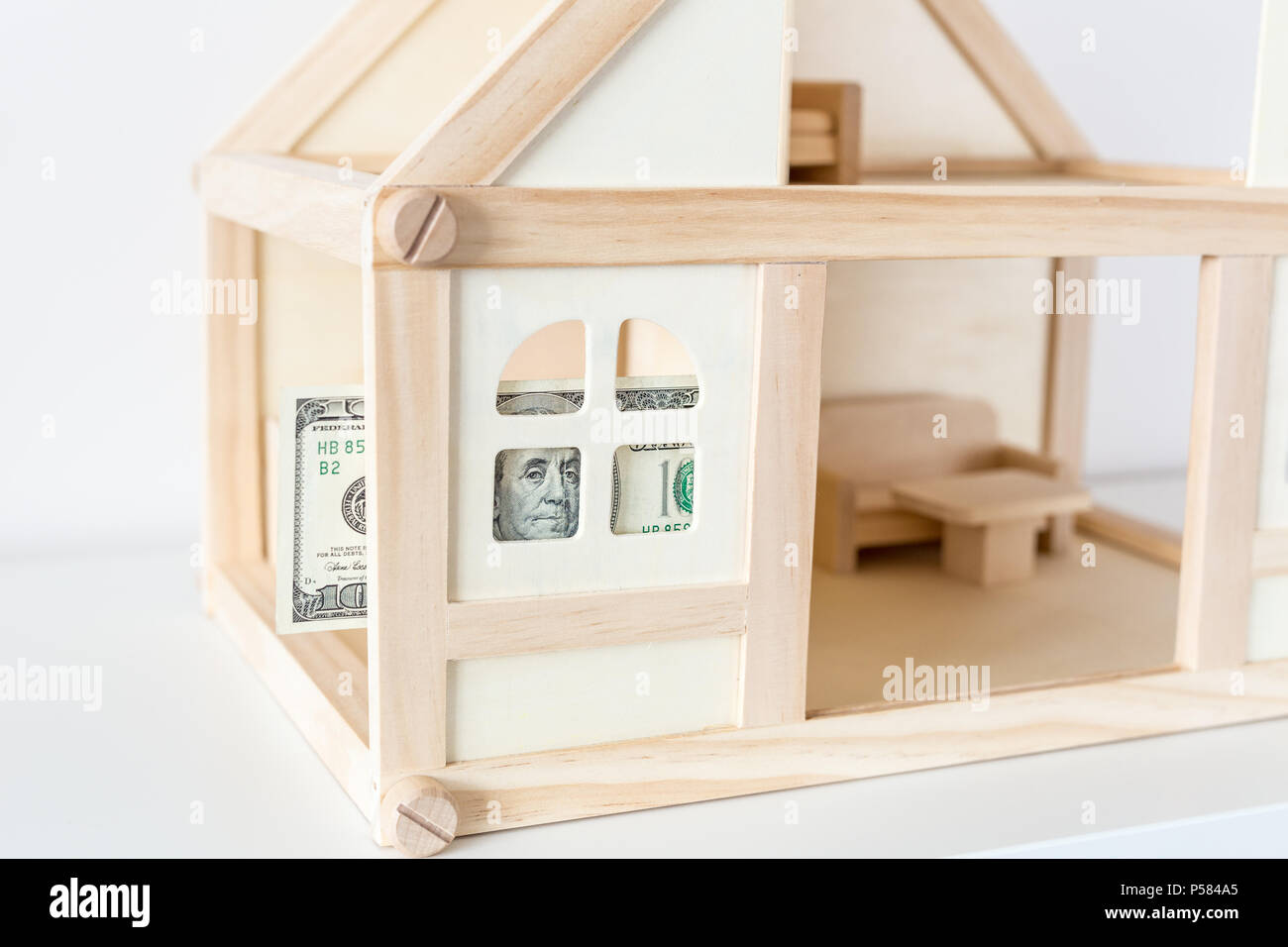 wooden house model with 100 dollar bill house rental and sale house expenses