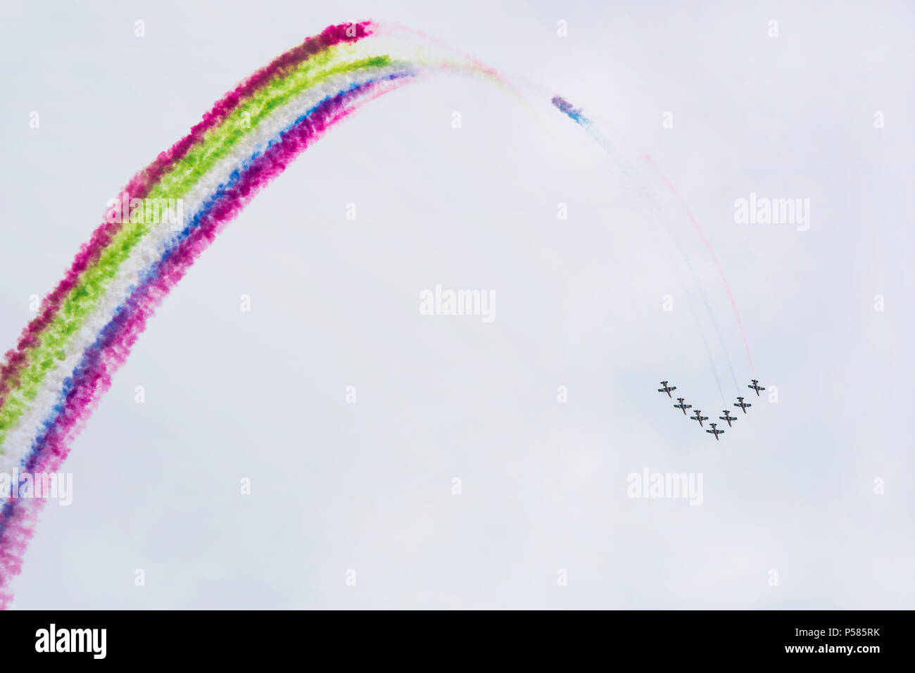 Airplanes on airshow with colorful multicolored trails of smoke against